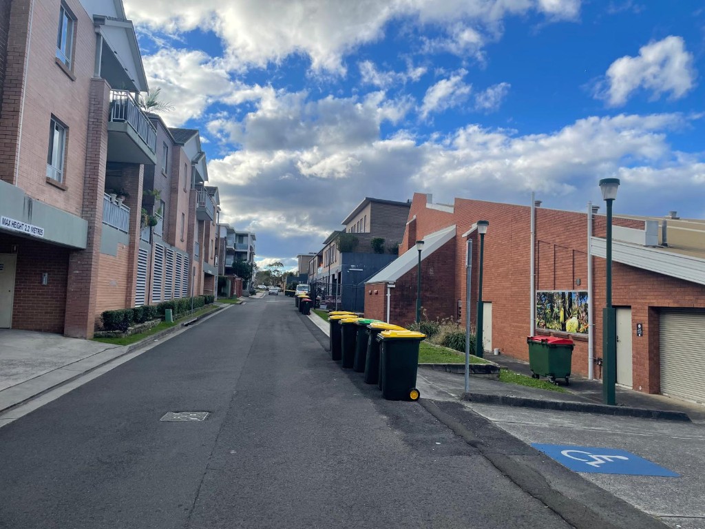 Street-level photograph of Gibbons Lane beside the Community Hall brick building